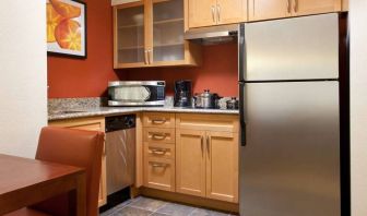 Guest room kitchen fitted with microwave, fridge-freezer, hob, and table at Sonesta ES Suites San Antonio Downtown Alamo Plaza.