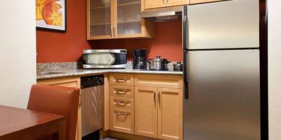 Guest room kitchen fitted with microwave, fridge-freezer, hob, and table at Sonesta ES Suites San Antonio Downtown Alamo Plaza.