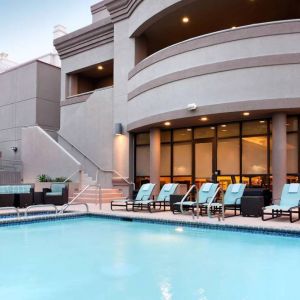 Sonesta ES Suites San Antonio Downtown Alamo Plaza’s outdoor pool has armchair and sofa seating by the side, as well as sun loungers.