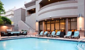 Sonesta ES Suites San Antonio Downtown Alamo Plaza’s outdoor pool has armchair and sofa seating by the side, as well as sun loungers.