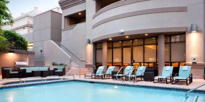 Sonesta ES Suites San Antonio Downtown Alamo Plaza’s outdoor pool has armchair and sofa seating by the side, as well as sun loungers.