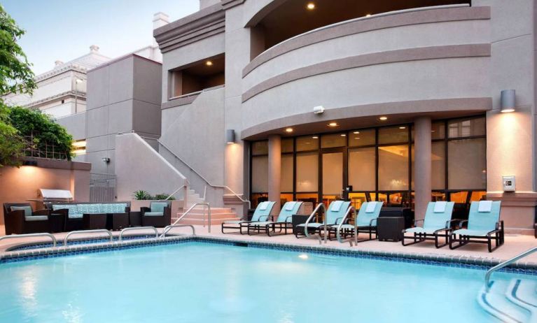 Sonesta ES Suites San Antonio Downtown Alamo Plaza’s outdoor pool has armchair and sofa seating by the side, as well as sun loungers.