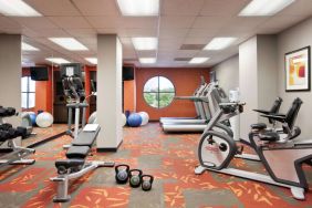 Fitness center with dumbbells, kettlebells, a variety of exercise machines and a TV, at Sonesta ES Suites San Antonio Downtown Alamo Plaza.