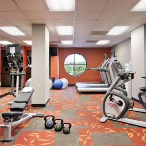 Fitness center with dumbbells, kettlebells, a variety of exercise machines and a TV, at Sonesta ES Suites San Antonio Downtown Alamo Plaza.