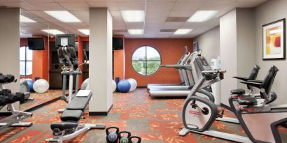 Fitness center with dumbbells, kettlebells, a variety of exercise machines and a TV, at Sonesta ES Suites San Antonio Downtown Alamo Plaza.