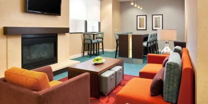 Sonesta ES Suites San Antonio Downtown Alamo Plaza’s lobby lounge has comfy seating, a fireplace, and a wall-mounted TV.