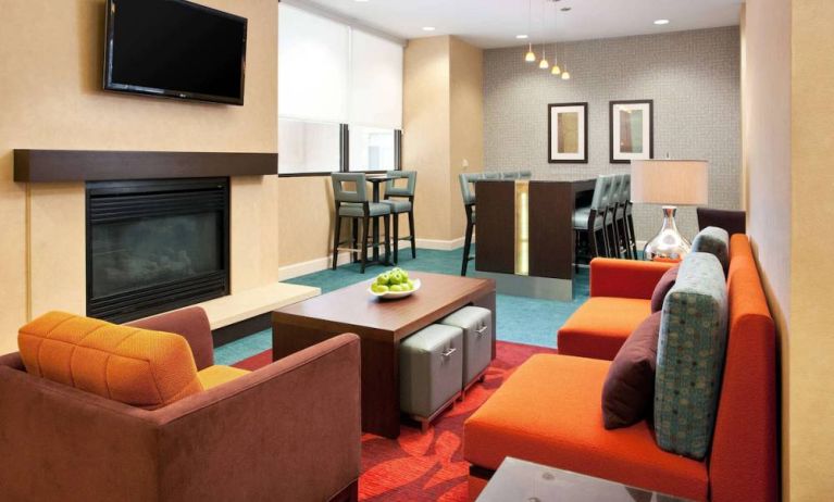 Sonesta ES Suites San Antonio Downtown Alamo Plaza’s lobby lounge has comfy seating, a fireplace, and a wall-mounted TV.