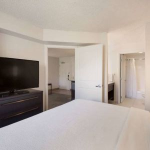 Sonesta ES Suites Reno double bed guest room, including ensuite bathroom and a widescreen TV.