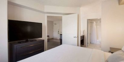 Sonesta ES Suites Reno double bed guest room, including ensuite bathroom and a widescreen TV.