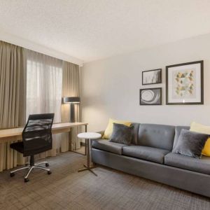 Guest room workspace desk and chair, with a window and nearby sofa, at Sonesta ES Suites Reno.