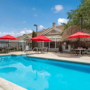 Sonesta ES Suites Reno’s outdoor pool has shaded tables and chairs by the side.