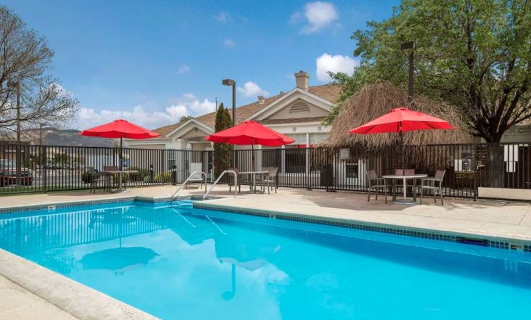 Sonesta ES Suites Reno’s outdoor pool has shaded tables and chairs by the side.