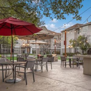 The hotel’s patio area includes shaded tables and chairs alongside barbecue facilities, making it ideal for dining and relaxing.