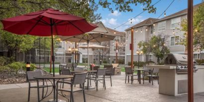 The hotel’s patio area includes shaded tables and chairs alongside barbecue facilities, making it ideal for dining and relaxing.