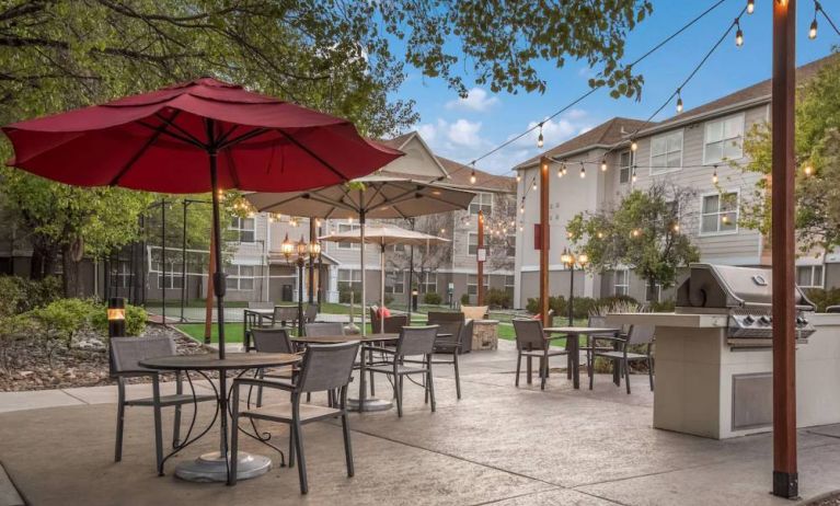 The hotel’s patio area includes shaded tables and chairs alongside barbecue facilities, making it ideal for dining and relaxing.