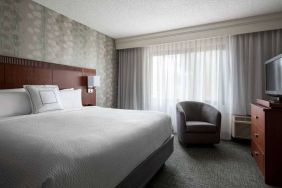 Double bed guest room in Sonesta Select Los Angeles LAX El Segundo, featuring armchair, window, and TV.