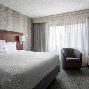 Double bed guest room in Sonesta Select Los Angeles LAX El Segundo, featuring armchair, window, and TV.