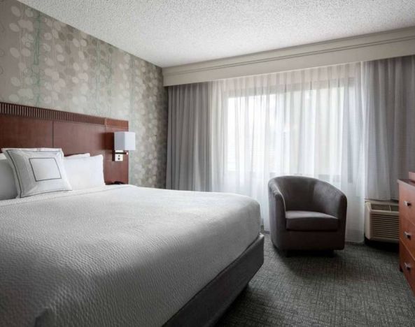 Double bed guest room in Sonesta Select Los Angeles LAX El Segundo, featuring armchair, window, and TV.