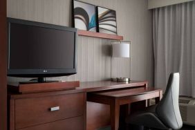 Guest room workspace in Sonesta Select Los Angeles LAX El Segundo, with chair, desk, lamp, and TV.