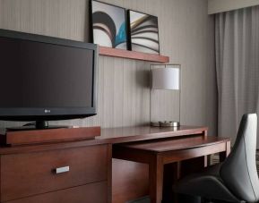 Guest room workspace in Sonesta Select Los Angeles LAX El Segundo, with chair, desk, lamp, and TV.