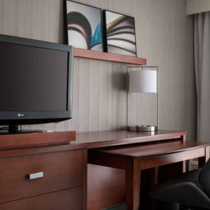 Guest room workspace in Sonesta Select Los Angeles LAX El Segundo, with chair, desk, lamp, and TV.