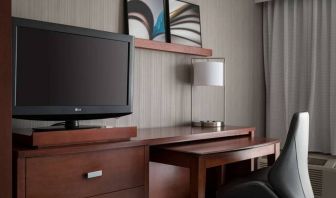 Guest room workspace in Sonesta Select Los Angeles LAX El Segundo, with chair, desk, lamp, and TV.