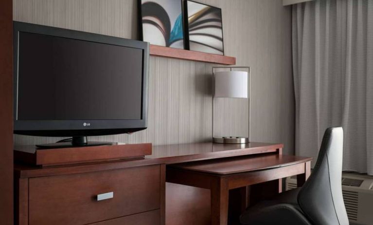 Guest room workspace in Sonesta Select Los Angeles LAX El Segundo, with chair, desk, lamp, and TV.