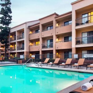 Sonesta Select Los Angeles LAX El Segundo’s outdoor pool has shaded tables and chairs, as well as sun loungers, by the side.