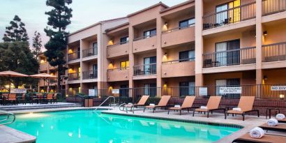 Sonesta Select Los Angeles LAX El Segundo’s outdoor pool has shaded tables and chairs, as well as sun loungers, by the side.