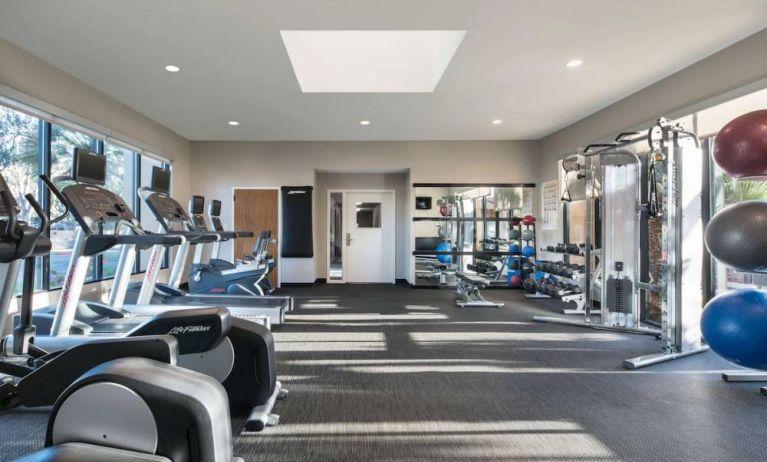 Fitness center equipped with free weights, gym balls, a TV, and various exercise machines at Sonesta Select Los Angeles LAX El Segundo.