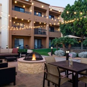 Fire pit with armchairs next to it, and more seating nearby, at Sonesta Select Los Angeles LAX El Segundo.