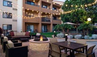 Fire pit with armchairs next to it, and more seating nearby, at Sonesta Select Los Angeles LAX El Segundo.