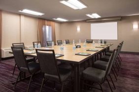 Hotel meeting room, with window, whiteboard, and seating for 14 around a large wooden table.