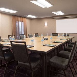 Hotel meeting room, with window, whiteboard, and seating for 14 around a large wooden table.