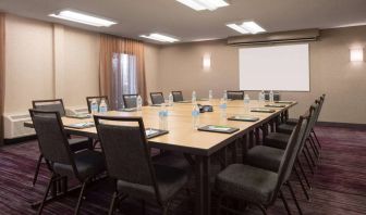 Hotel meeting room, with window, whiteboard, and seating for 14 around a large wooden table.