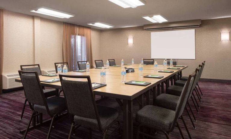 Hotel meeting room, with window, whiteboard, and seating for 14 around a large wooden table.