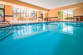 Indoor pool with large windows and tables and chairs at Sonesta Select Kansas City South Overland Park.