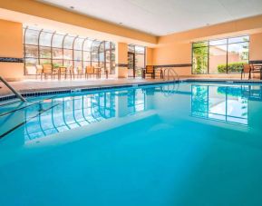 Indoor pool with large windows and tables and chairs at Sonesta Select Kansas City South Overland Park.