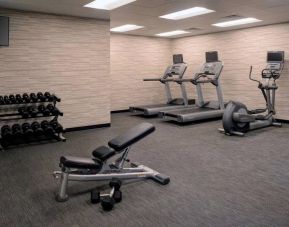 Fitness center furnished with free weights, assorted exercise machines, and a TV at Sonesta Select Kansas City South Overland Park.