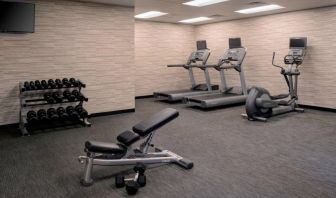 Fitness center furnished with free weights, assorted exercise machines, and a TV at Sonesta Select Kansas City South Overland Park.