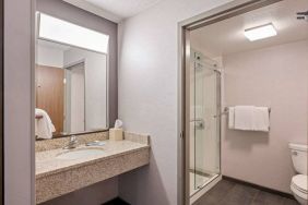 Sonesta Select Pleasant Hill guest bathroom, including shower, lavatory, mirror, and sink.