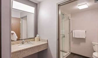 Sonesta Select Pleasant Hill guest bathroom, including shower, lavatory, mirror, and sink.