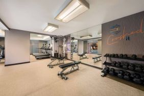 Sonesta Select Pleasant Hill’s fitness center features free weights, a mirrored wall, and various exercise machines.