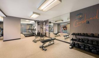 Sonesta Select Pleasant Hill’s fitness center features free weights, a mirrored wall, and various exercise machines.