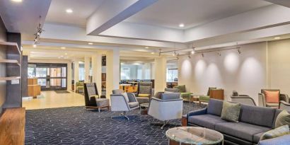 Sonesta Select Pleasant Hill’s lobby lounge is furnished with abundant armchair and sofa seating and coffee tables.