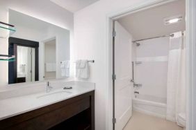 Guest bathroom in Sonesta ES Suites Atlanta Alpharetta North Point Mall featuring shower-equipped bath, lavatory, mirror, and sink.