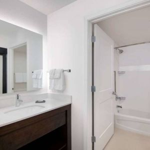 Guest bathroom in Sonesta ES Suites Atlanta Alpharetta North Point Mall featuring shower-equipped bath, lavatory, mirror, and sink.