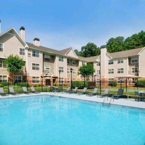 Sonesta ES Suites Atlanta Alpharetta North Point Mall’s outdoor pool has tables and chairs, and sun loungers, by the side.