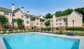 Sonesta ES Suites Atlanta Alpharetta North Point Mall’s outdoor pool has tables and chairs, and sun loungers, by the side.