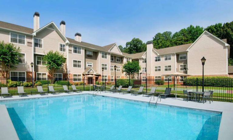 Sonesta ES Suites Atlanta Alpharetta North Point Mall’s outdoor pool has tables and chairs, and sun loungers, by the side.